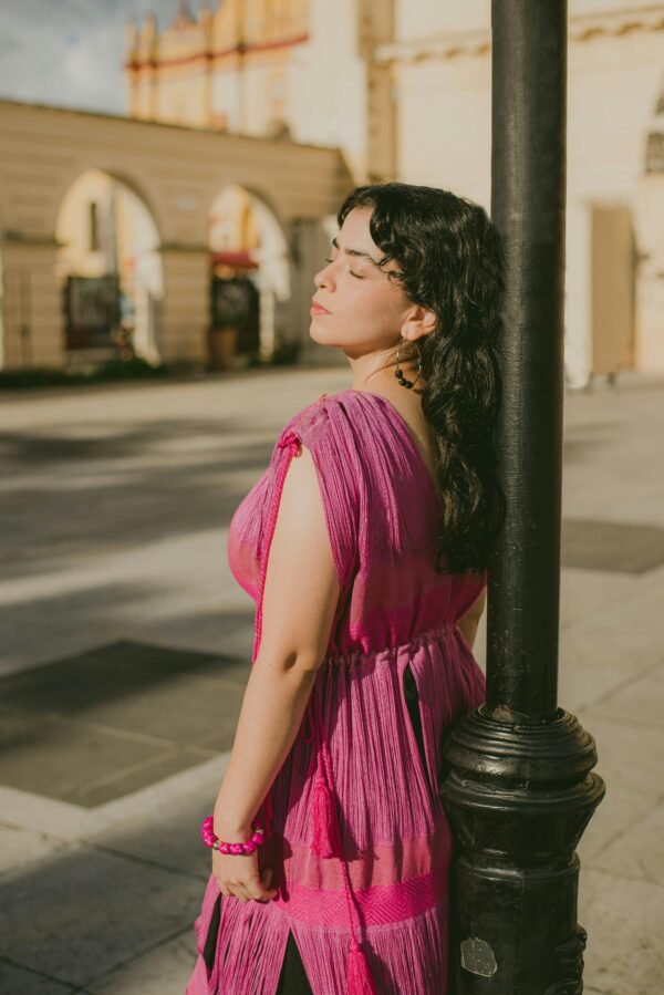 Woman in Pink Dress Leaning on Lamppost